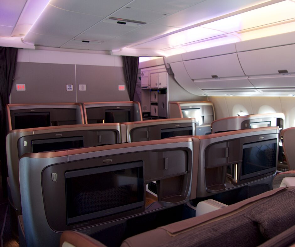 Business class seats with entertainment screens in an airplane.