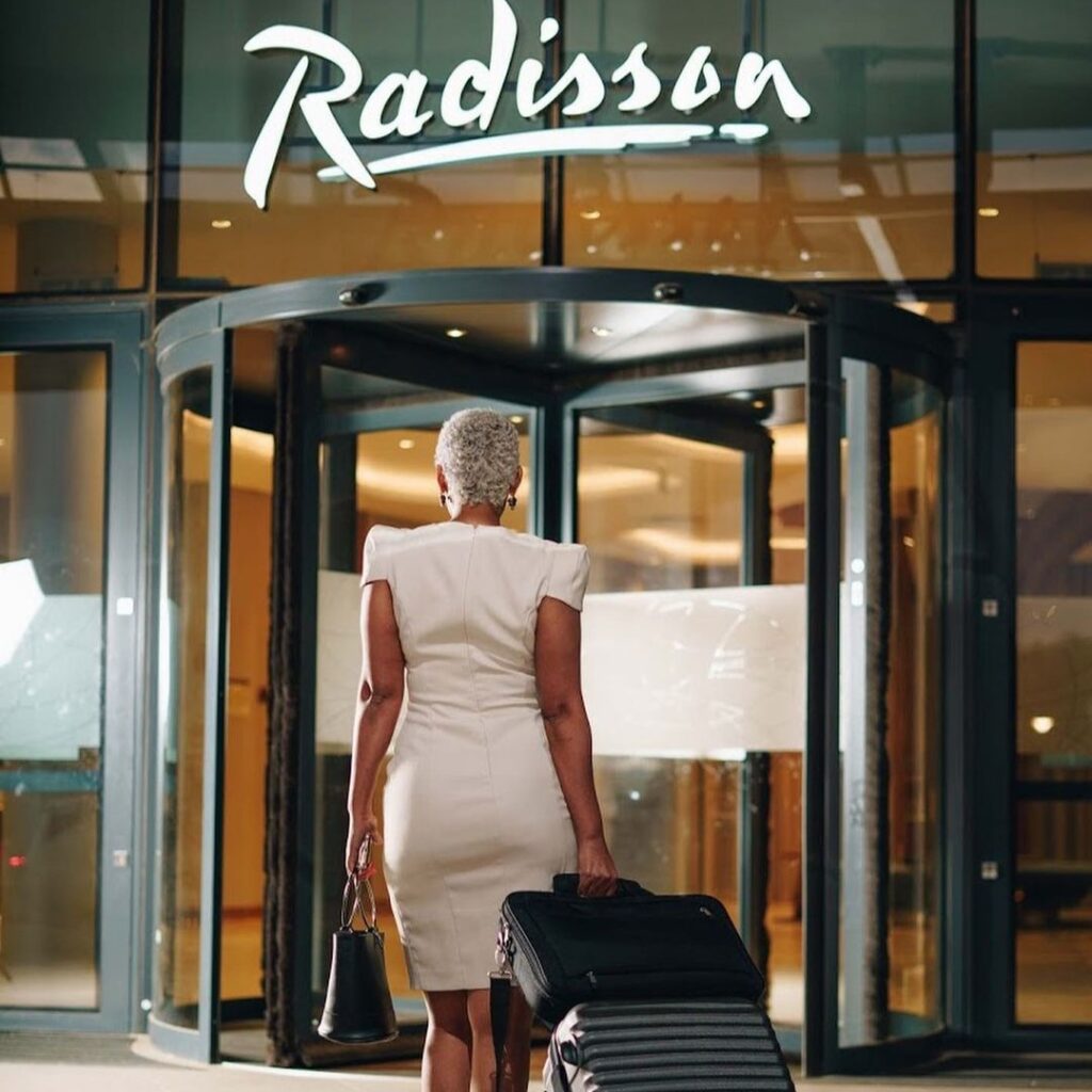 Woman entering a Radisson hotel.