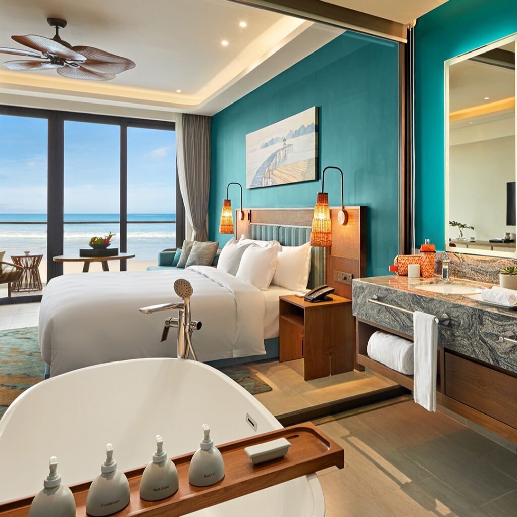 View inside an ALL hotel room with view of the beach on the window.