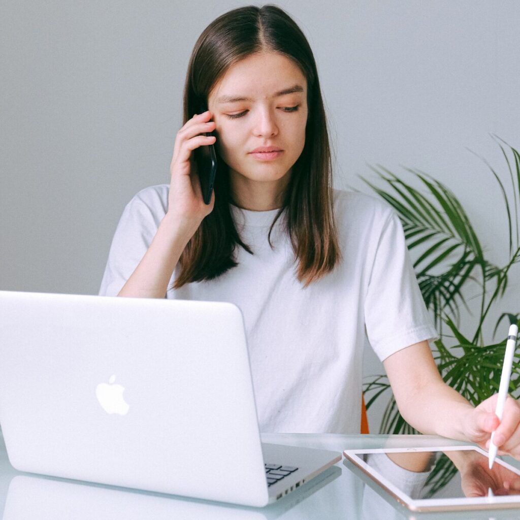 Woman on the phone while using tablet.