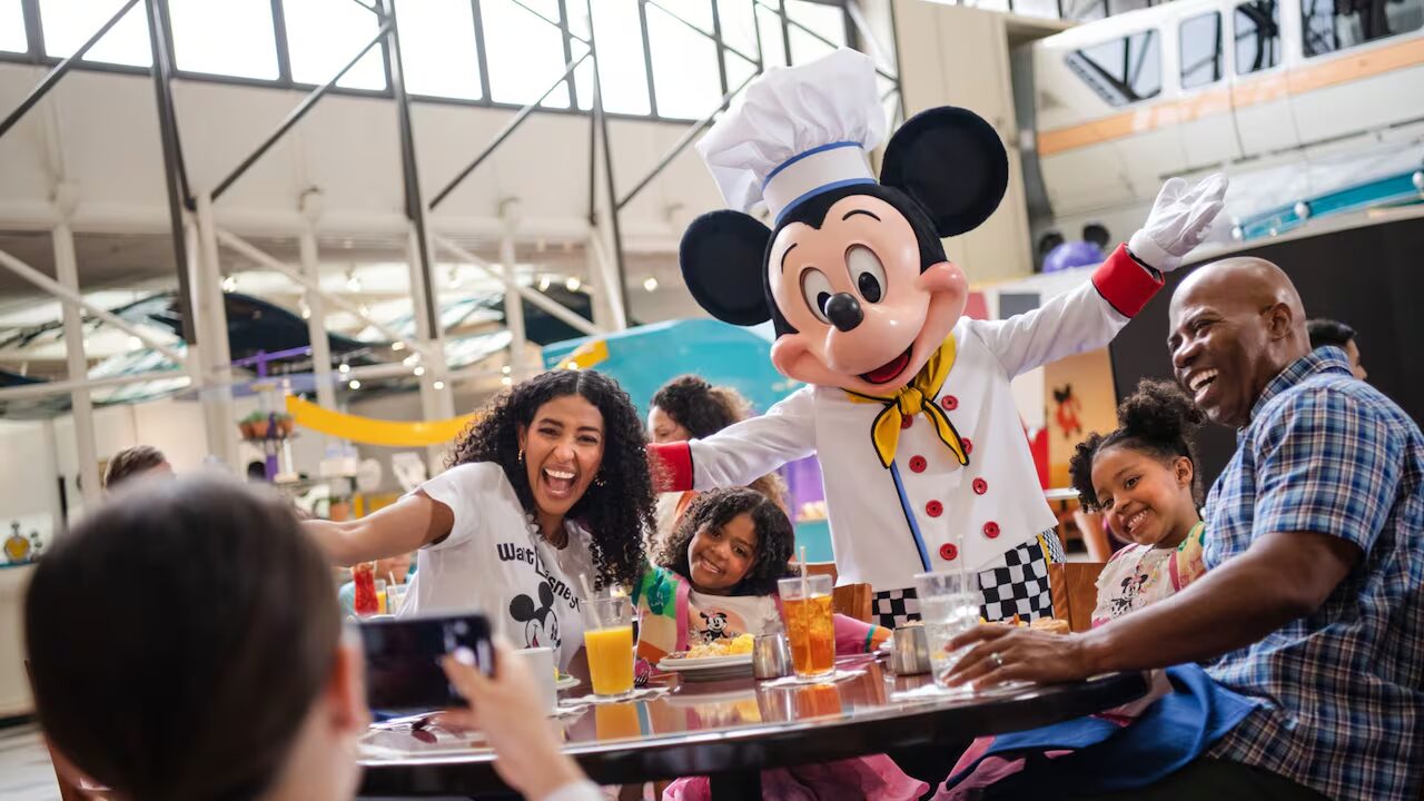 Family dining and taking a picture with Mickey Mouse.