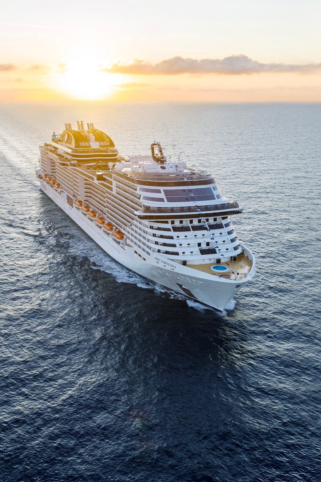 MSC Virtuosa at sea with sunset in the background.
